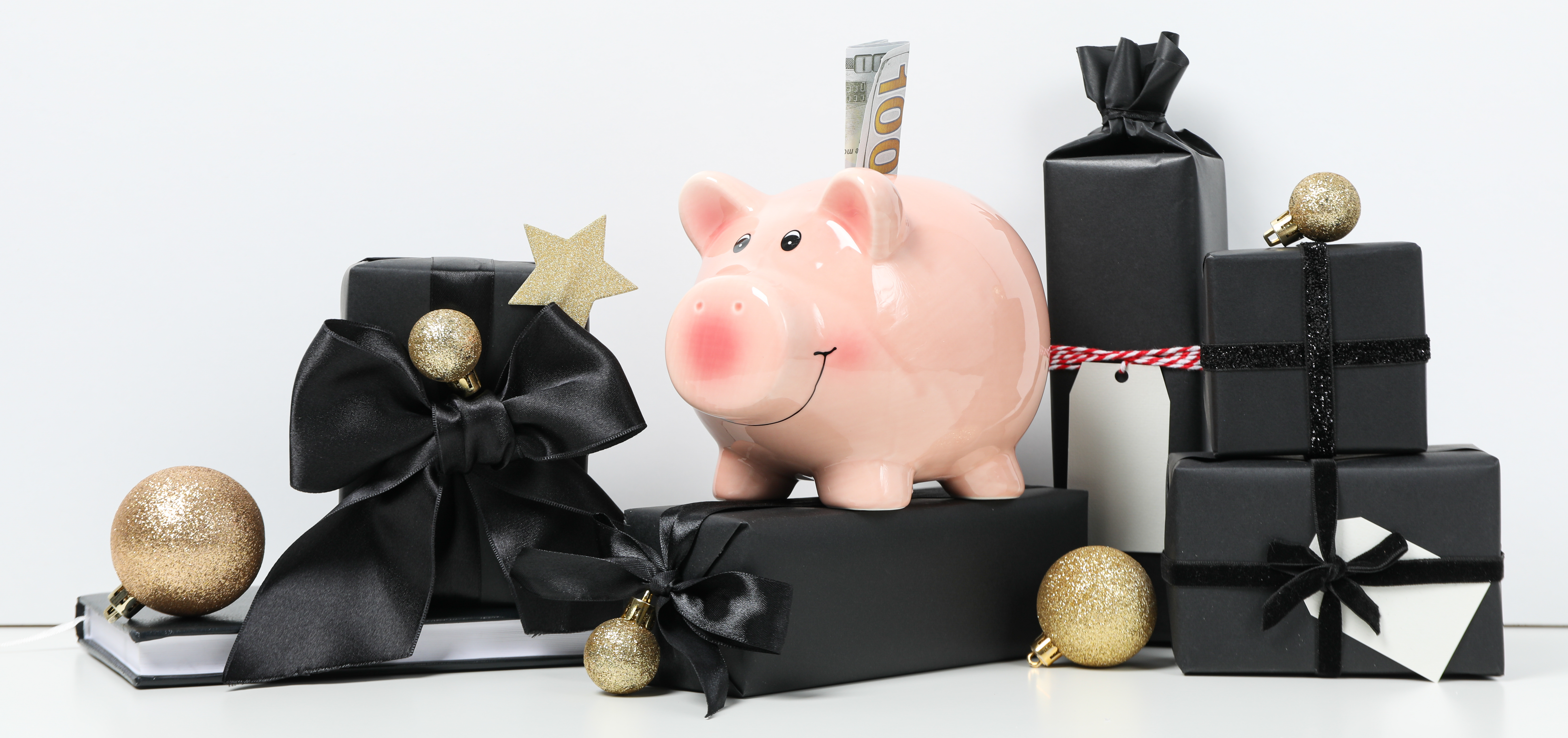 piggy bank with one hundred dollar sitty with black presents and gold Christmas balls