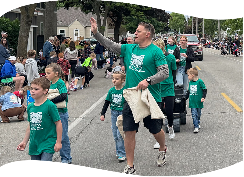FCB employee waving to crowd in a parade