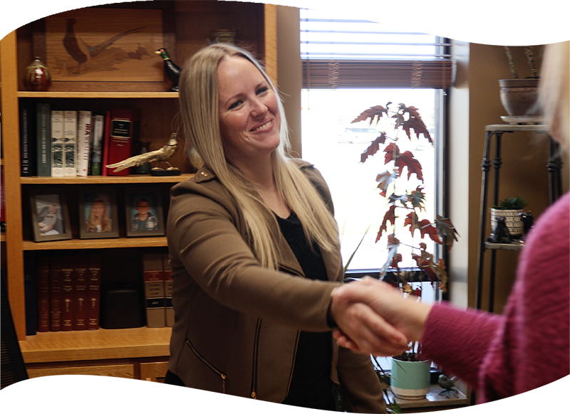 Chelsea Frederick shaking a client's had in office