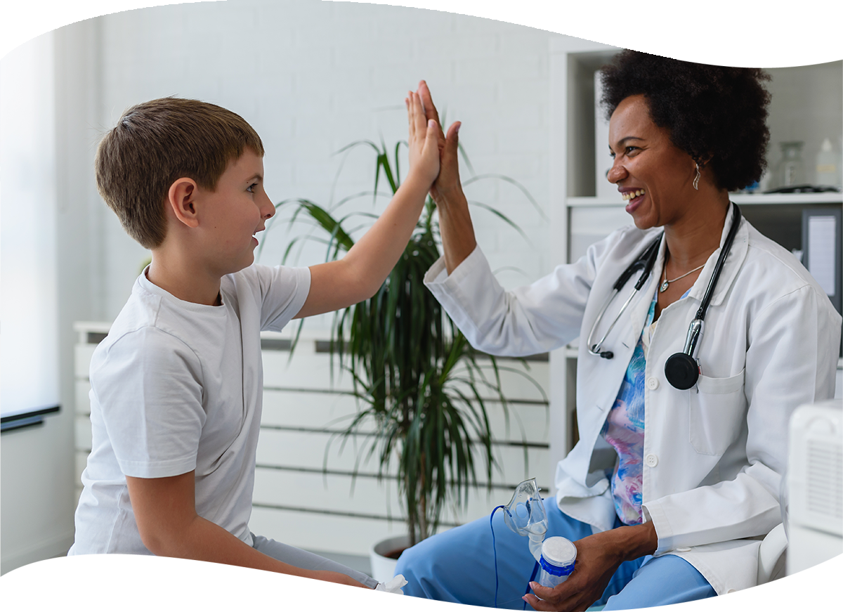 female doctor giving a child patient a high five in the office