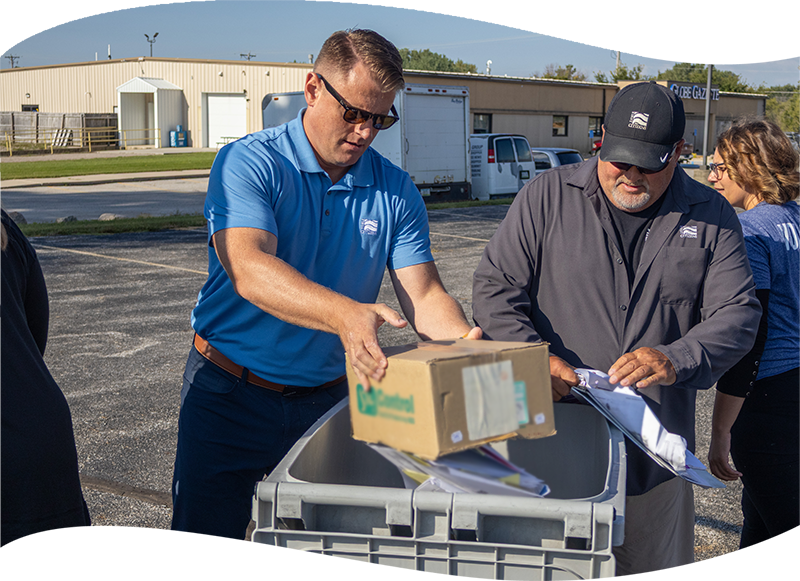 employees dumping shred into recycle bin